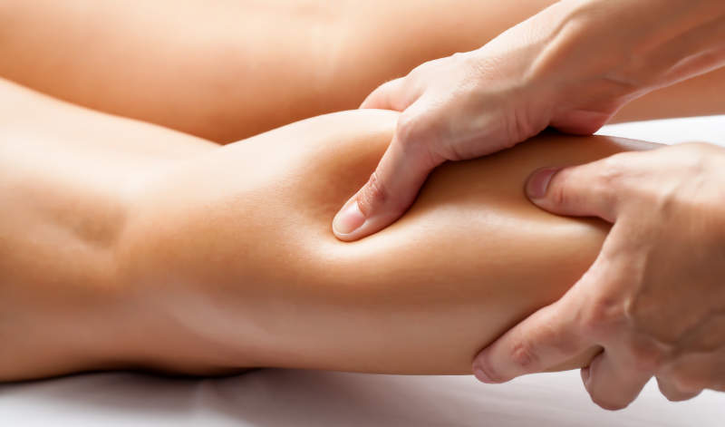 Practitioner assessing an athlete's calf injury at Uprise Health